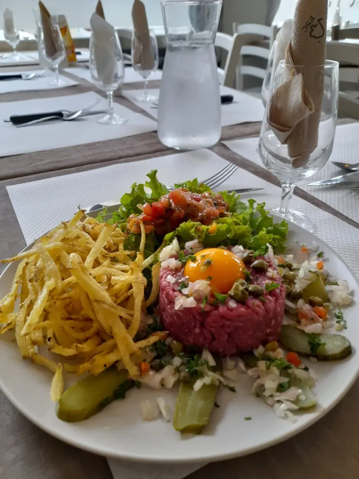 Steak tartare et frites maison dressés en salle, au restaurant Le Pari's